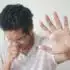 a man holding his hand up in front of his face