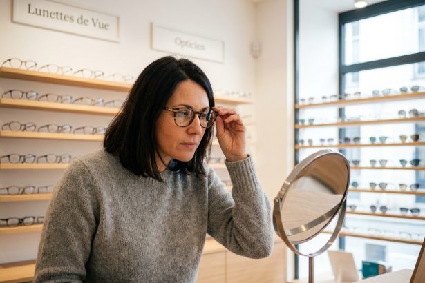 Femme essayant des lunettes dans une boutique d'opticien moderne près de Saint-Étienne