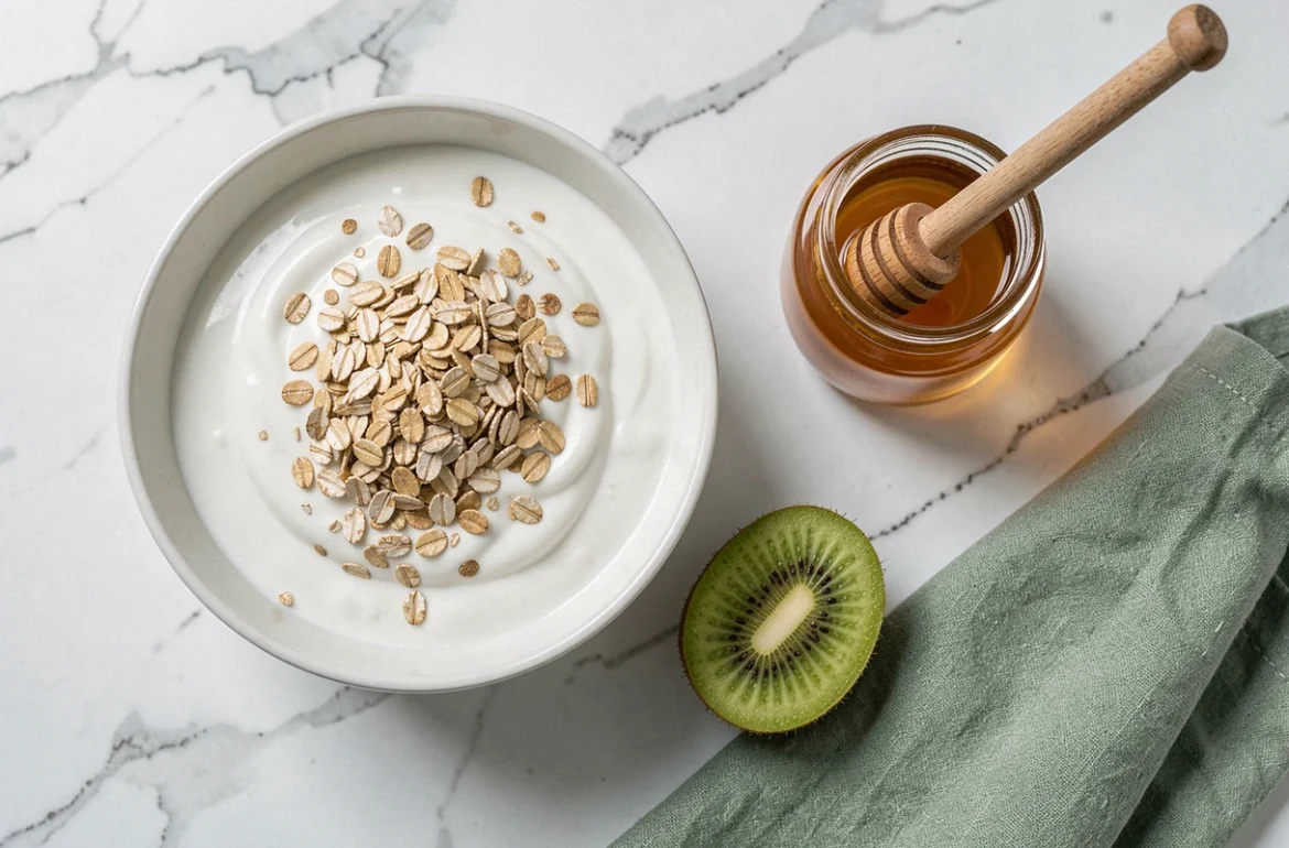 Vue de dessus d'un petit-déjeuner sain avec yaourt au son d'avoine, kiwi et miel sur marbre blanc